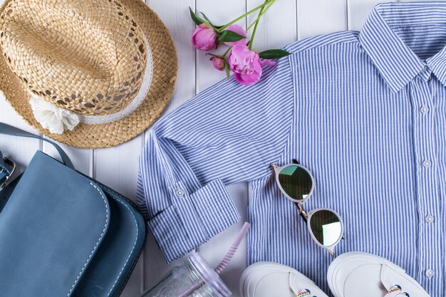 Flat lay  woman summer clothes and accessories collage on white  with shirt, jeans, glasses, shoes, handbag, hat, Jar