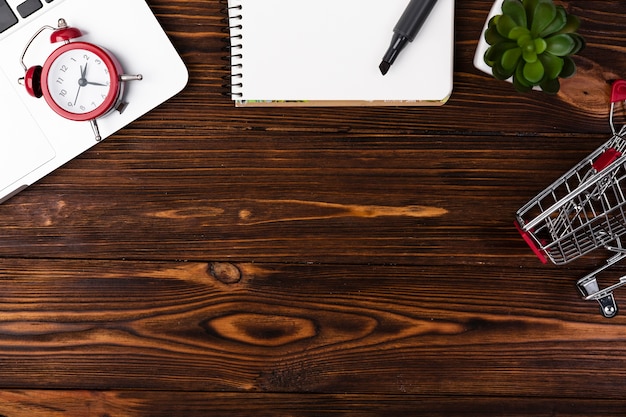 Flat lay wooden desk with shopping cart