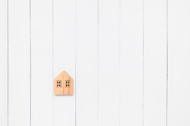 Photo flat lay of the wooden house model on white table background