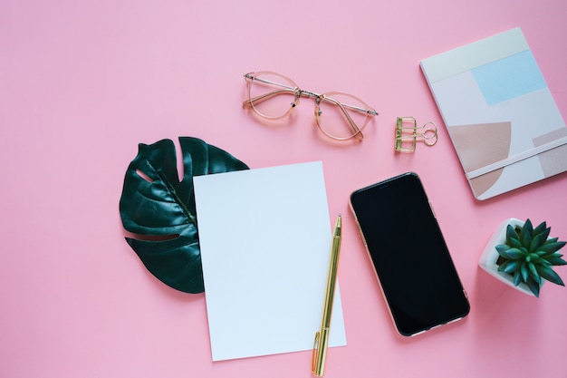 Flat lay of workspace desk, minimal stationery with smartphone and notebook