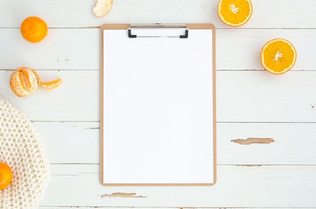 Flat lay workspace with a clipboard on white wooden planks. 