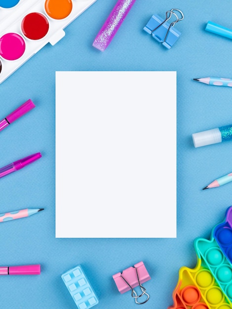 Flat layout of blank notepad with pen watercolor pop it and stickers on colorful background