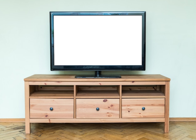 Flat LCD television on brown wooden cabinet in the living room.