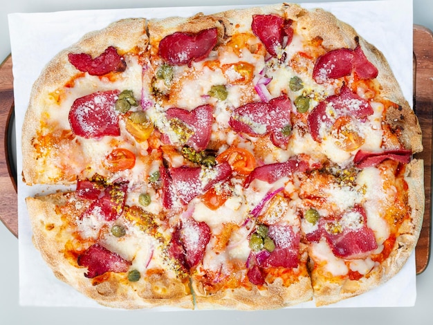 Flat pizza on a wooden pizza board top view Grey background