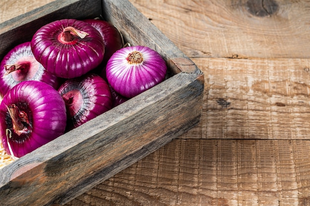 Flat red sweet onion in wooden box