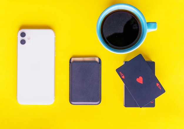Foto vista piatta portafoglio mobile carte tazza di caffè sfondo giallo