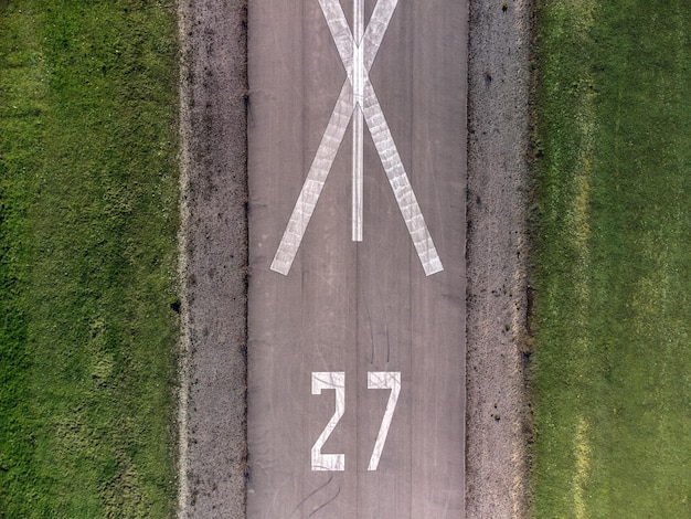 Flat view of a runway with the number 27 marked