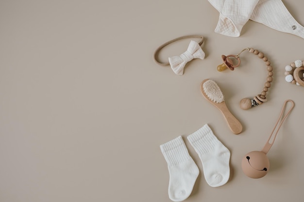 Flatlay aesthetic Scandinavian newborn baby care accessories toys collage on neutral pastel beige colour background Trendy elegant luxury infant set Top view