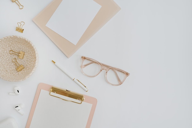 Photo flatlay blank copy space clipboard clips in rattan plate on white background home office desk workspace aesthetic business work template flat lay top view