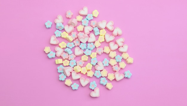 Photo flatlay colorful marshmallows on sweet pink background with copy space