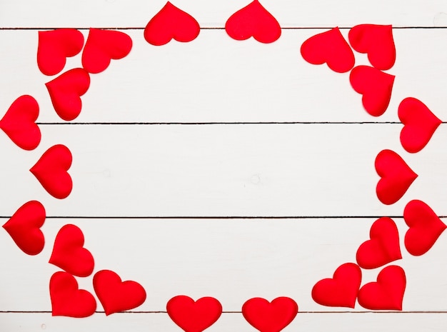 Flatlay composition with hearts on a wooden background.