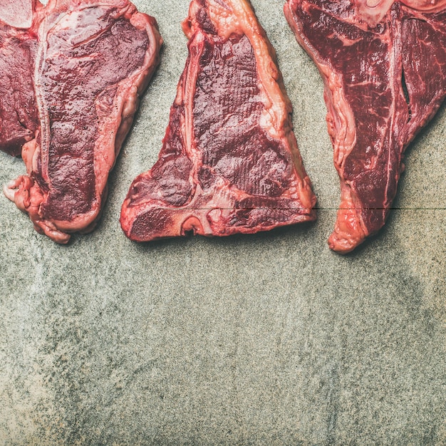 Flatlay of fresh raw beef meat steaks square crop