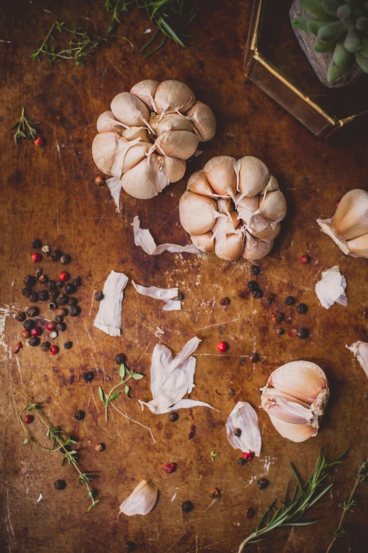 Flatlay Чеснок черный перец и розмарин на деревенском фоне