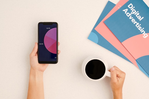 Photo flatlay of hands of contemporary businessperson having coffee and analyzing financial diagram