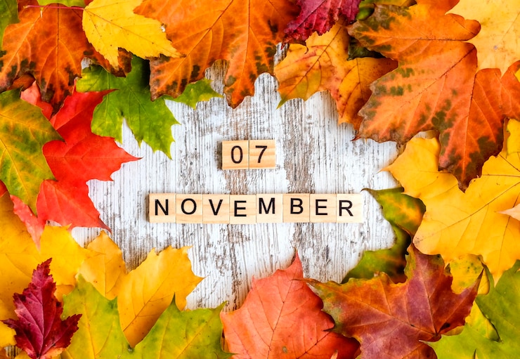 Foto flatlay herfst esdoorn gebladerte inscriptie 07 november in houten letters op tafel