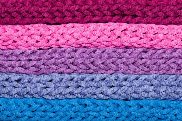 Flatlay horizontal rows of blue and pink braided fabric Macro picture of knitted woven rough threads