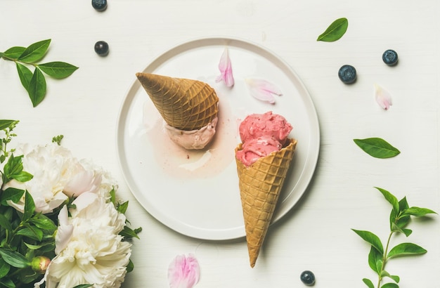 Flatlay of ice cream scoops and peonies on plate