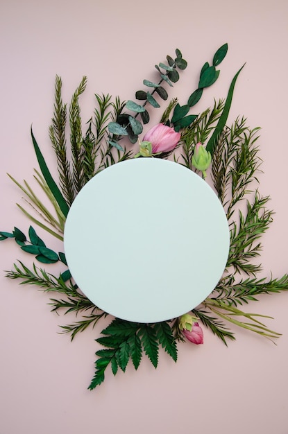 Flatlay on light cold pink background mockup copyspace white circle framed by herbal twigs