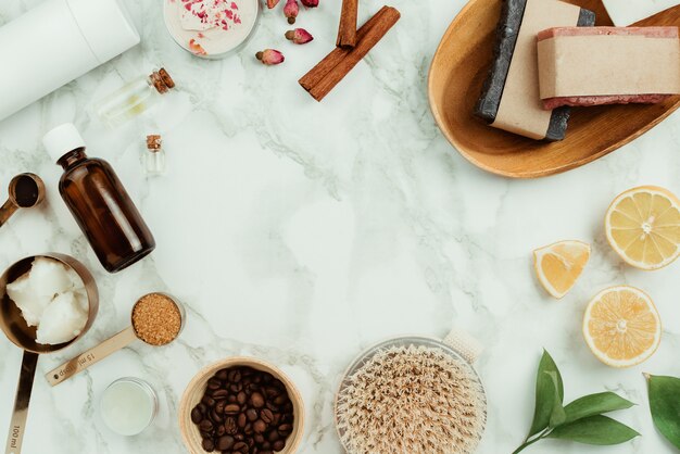 Flatlay of various natural homemade cosmetics and ingredients: essential oils, coffee, sugar, soap