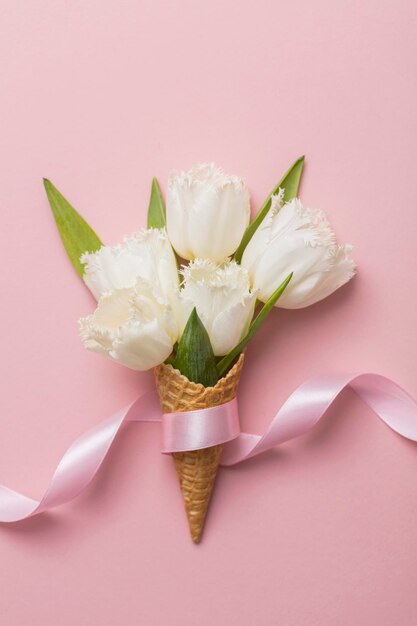 Flatlay waffle cone with white flower blossom