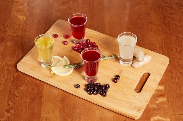 Flavored fruit liqueurs on wooden board