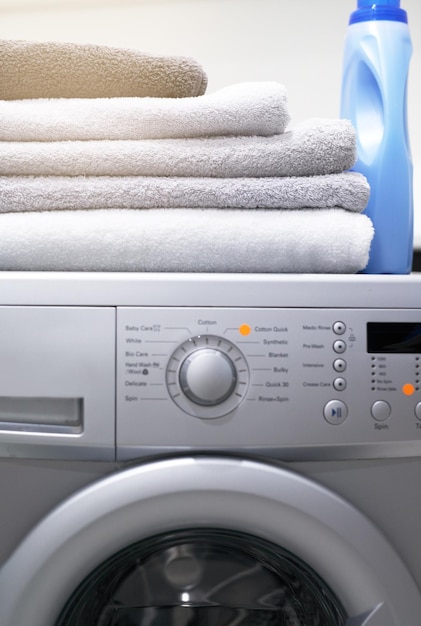 Flawless functionality for your laundry needs Shot of a washing machine with folded towels and detergent on top of it