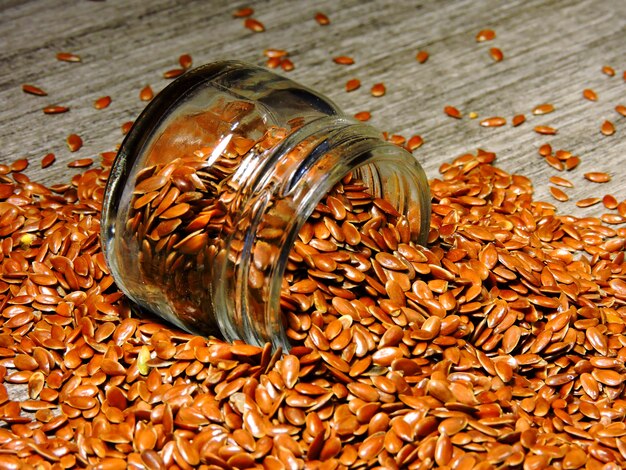 Flax seeds are poured from a glass jar.