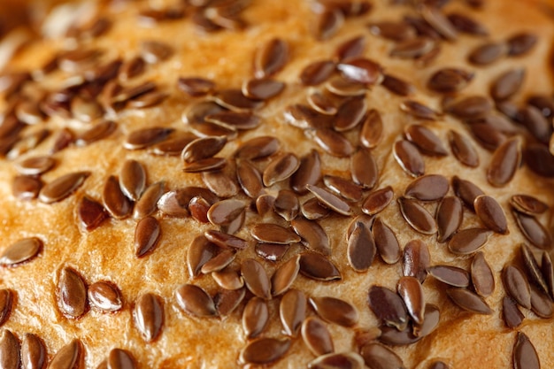 Flax seeds closeup sprinkled on baking bread and bakery products selective focus