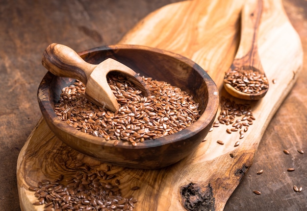 Flax seeds or line in bowl on wooden table