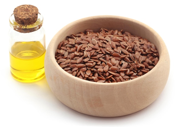 Flax seeds and oil in a jar over white background