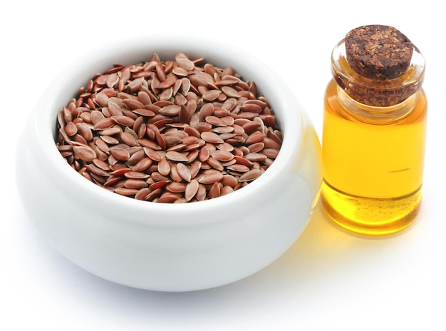 Flax seeds and oil in a jar over white background