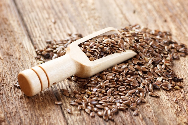 Flax seeds in scoop on wooden table