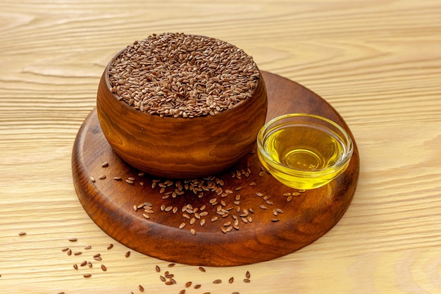 Flax seeds in a spoon and bowl with a bottle of flaxseed oil