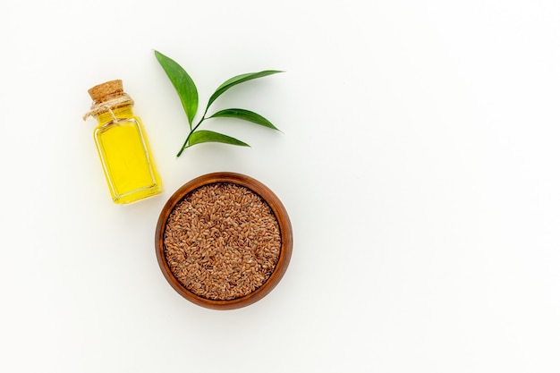 Photo flax seeds in a spoon and bowl with a bottle of flaxseed oil