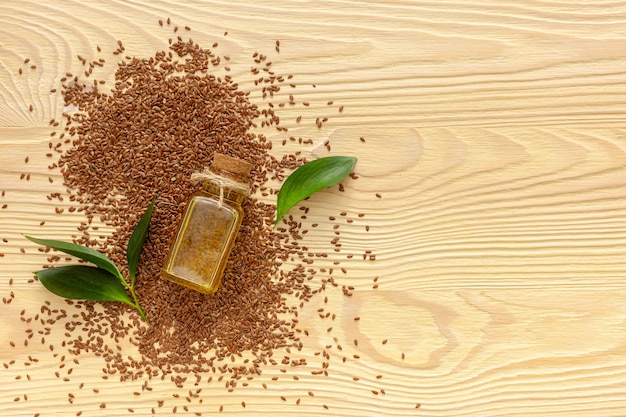 Photo flax seeds in a spoon and bowl with a bottle of flaxseed oil