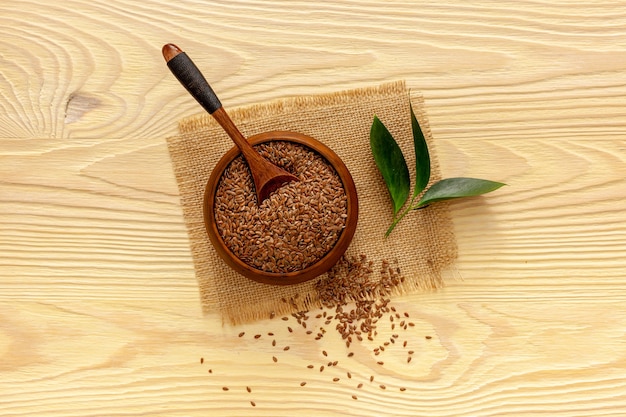 Flax seeds in a spoon and bowl with a bottle of flaxseed oil