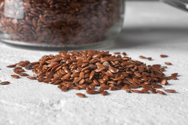 Flax seeds in a transparent jar A handful of seeds on the table