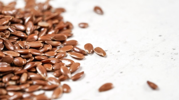 Flax seeds on white stone board, close up detail, with space for text right side