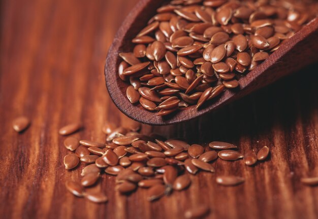 The flax seeds in a wooden bowl close up