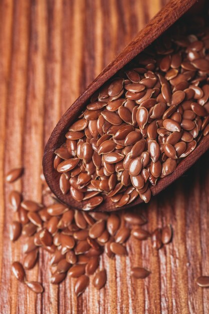 The flax seeds in a wooden bowl close up