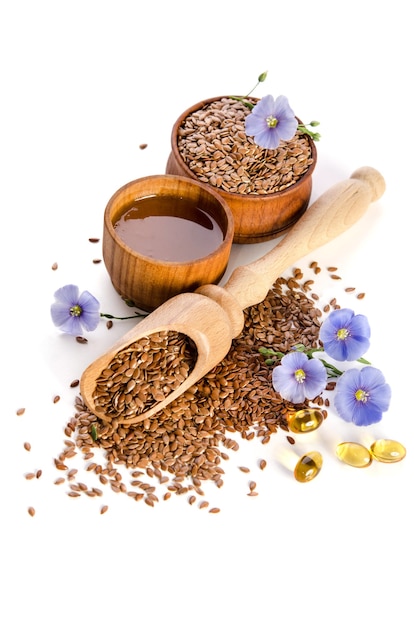 Flax seeds in wooden scoop and bowl with oil