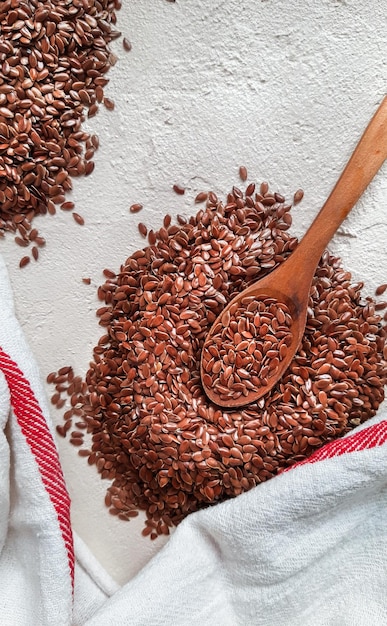 Flax seeds in wooden spoon on white background