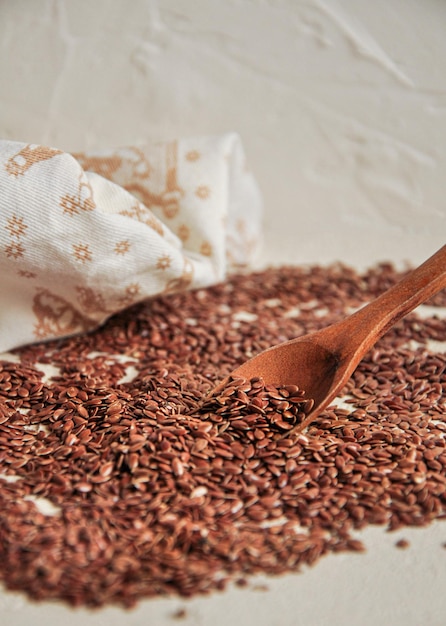 Flax seeds in wooden spoon on white background