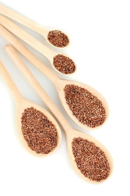 Flax seeds in wooden spoons on white background closeup