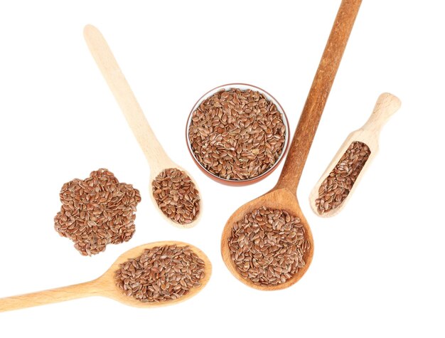 Flax seeds in wooden spoons on white background closeup