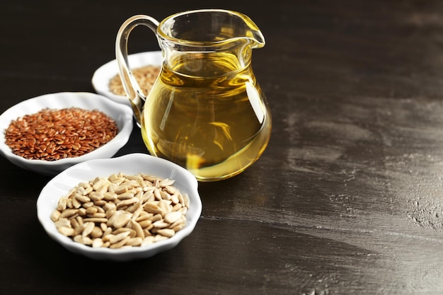 Flax and sunflower seeds with oil on wooden table