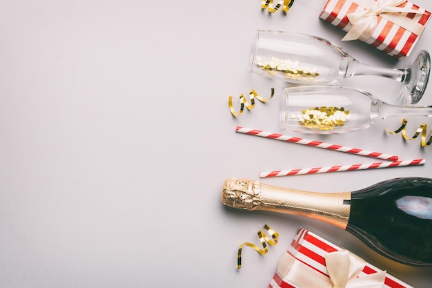 Fles champagne met gekleurde glitter confetti en geschenkdoos ruimte voor tekst op kleurrijke achtergrond bovenaanzicht Hilarische kerst- en verjaardagsviering