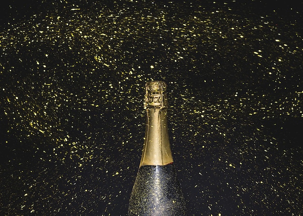 Foto fles champagne vliegende gouden glitter hoge kwaliteit en resolutie mooie foto concept