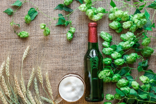 Fles en glas bier met brouwingrediënten hopbloem met tarwe bovenaanzicht