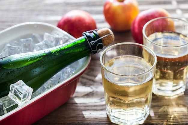 Fles en twee glazen cider op het houten oppervlak